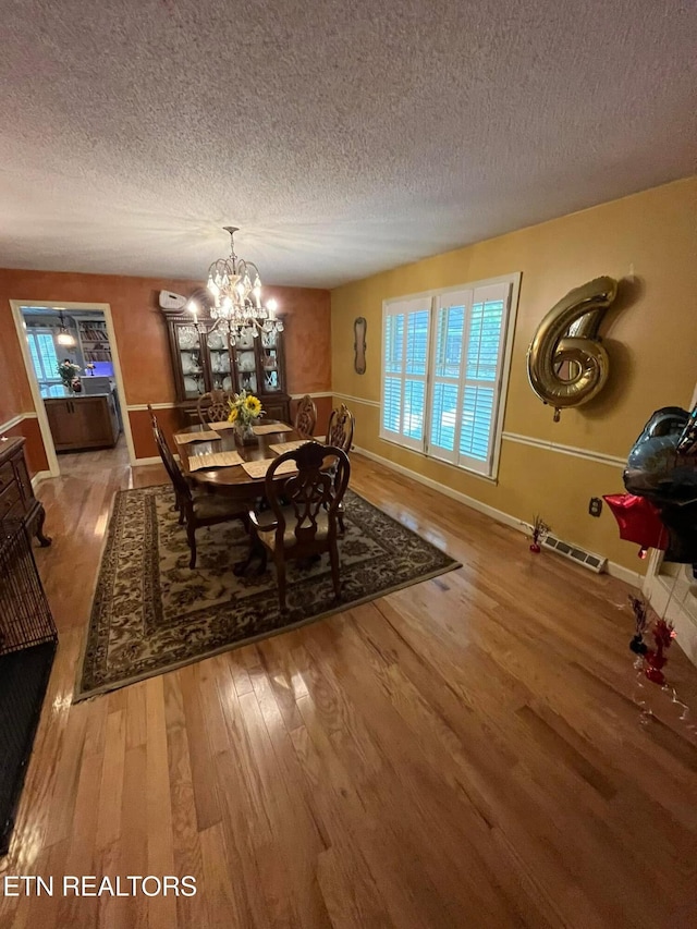 242 Adams Ln, Jellico, TN 37762 - dining space with wood finished floors, a textured ceiling, and a chandelier