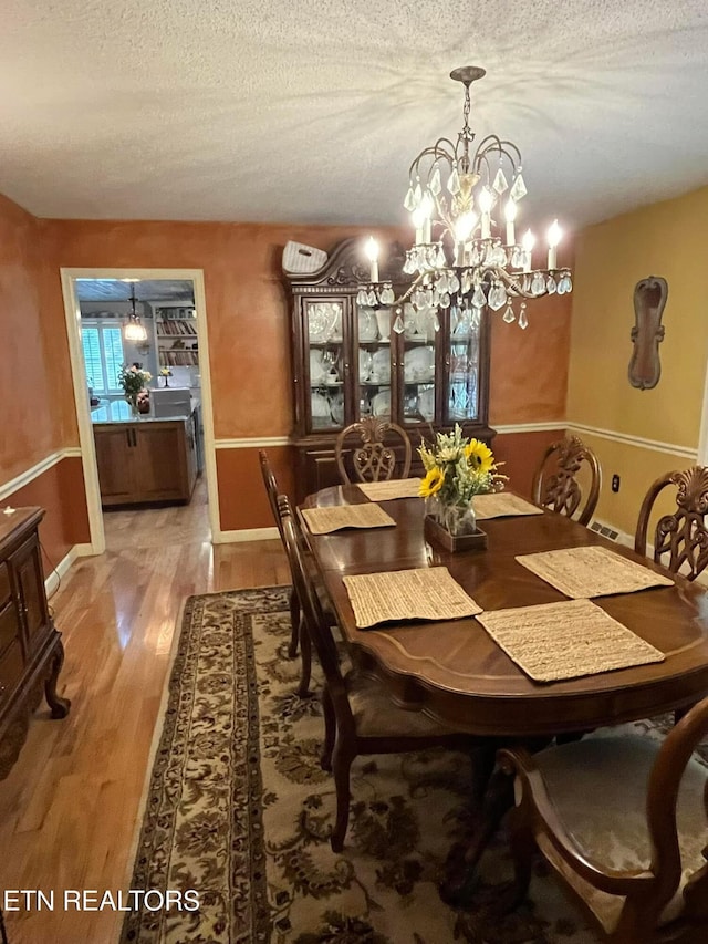 242 Adams Ln, Jellico, TN 37762 - dining area with a textured ceiling, light wood finished floors, and a chandelier