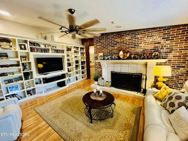 242 Adams Ln, Jellico, TN 37762 - living room featuring ceiling fan, brick wall, wood finished floors, a tiled fireplace, and recessed lighting