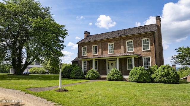 2590 Day Rd, Strawberry Plains, TN 37871 - colonial house with a chimney, brick siding, covered porch, a front yard, and a standing seam roof