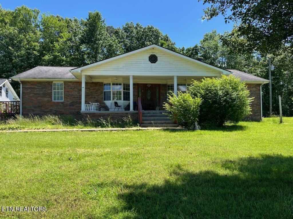 165 Bud Hatmaker Ln, Lafollette, TN 37766 - view of front of home with a porch, a front lawn, and brick siding