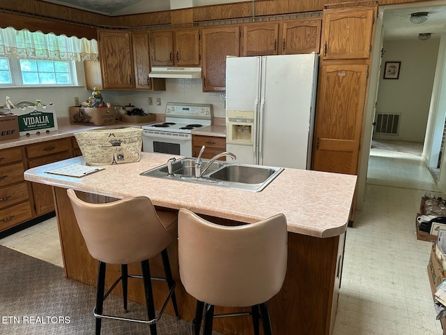 165 Bud Hatmaker Ln, Lafollette, TN 37766 - kitchen featuring white appliances, under cabinet range hood, light countertops, and brown cabinets