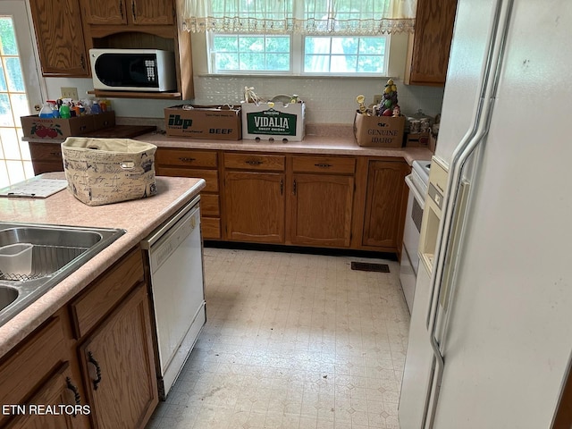 165 Bud Hatmaker Ln, Lafollette, TN 37766 - kitchen featuring white appliances, brown cabinetry, light flooring, decorative backsplash, and light countertops