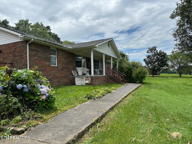 165 Bud Hatmaker Ln, Lafollette, TN 37766 - view of property exterior featuring covered porch, brick siding, and a yard