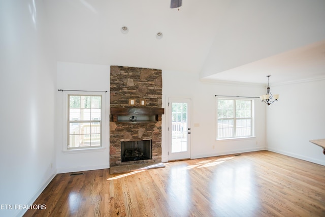 7481 Nightfall Cir, Ooltewah, TN 37363 - unfurnished living room featuring wood finished floors, a fireplace, a chandelier, and high vaulted ceiling