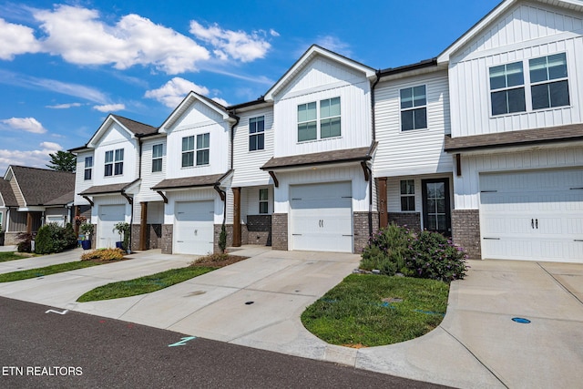 205 Harper Village Way, Lenoir City, TN 37771 - view of property featuring brick siding, concrete driveway, a garage, and board and batten siding