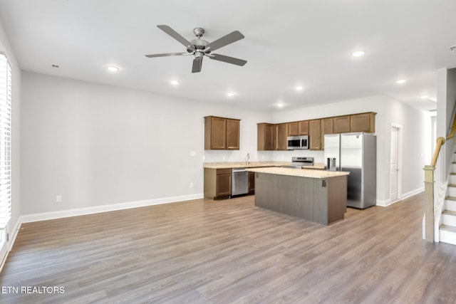 205 Harper Village Way, Lenoir City, TN 37771 - kitchen featuring stainless steel appliances, a kitchen island, a ceiling fan, light countertops, and light wood finished floors