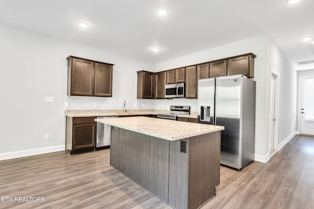 205 Harper Village Way, Lenoir City, TN 37771 - kitchen with stainless steel appliances, dark brown cabinets, light wood-style flooring, a kitchen island, and recessed lighting