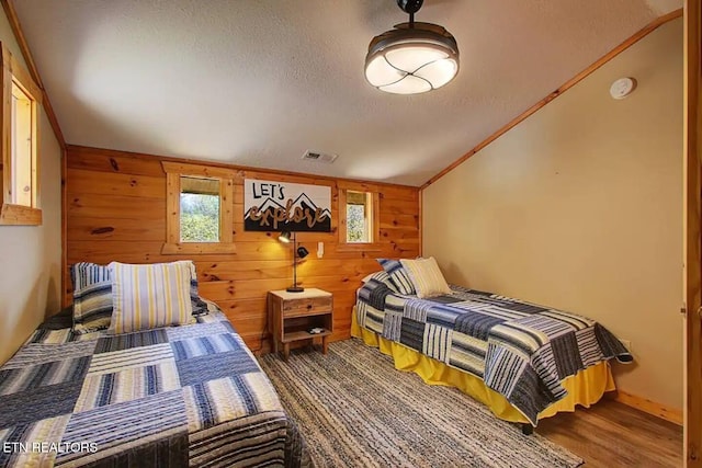 920 Falcon View Way, Sevierville, TN 37862 - bedroom with lofted ceiling, wood walls, a textured ceiling, and wood finished floors
