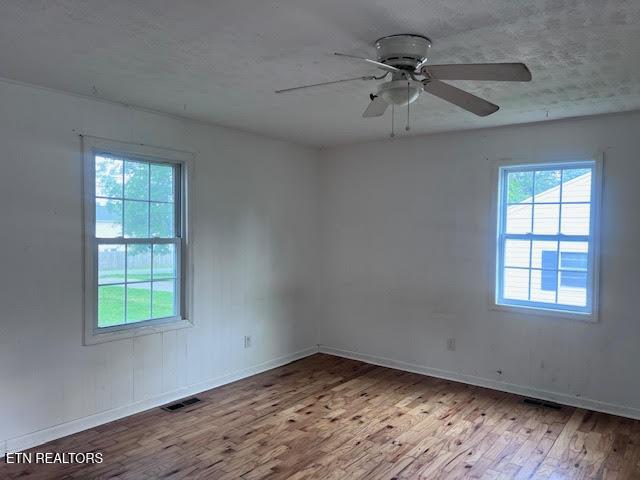 7832 Brickyard Rd, Powell, TN 37849 - unfurnished room featuring wood finished floors, a ceiling fan, and baseboards