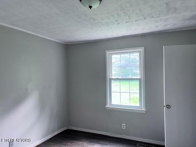 7832 Brickyard Rd, Powell, TN 37849 - empty room with a textured ceiling, baseboards, dark wood-style floors, and ornamental molding