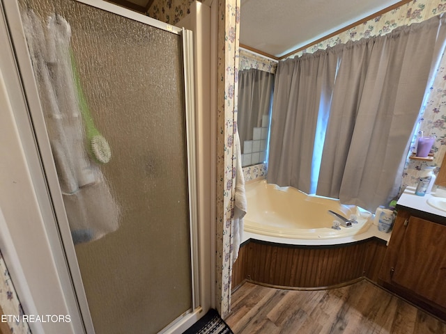417 Ely Town Rd, Dryden, VA 24243 - bathroom featuring wood finished floors, a shower stall, vanity, a garden tub, and wallpapered walls