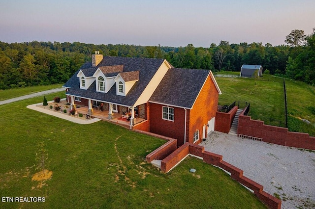 3292 Moss Arcott Rd, Celina, TN 38551 - cape cod-style house featuring a chimney, covered porch, driveway, and a front yard