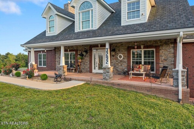 3292 Moss Arcott Rd, Celina, TN 38551 - view of front of property with covered porch, a front lawn, and a shingled roof