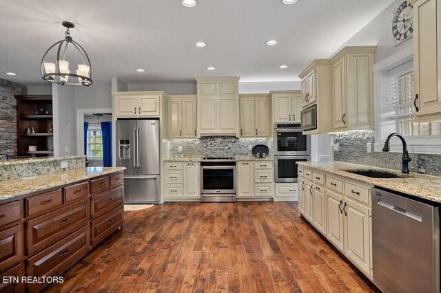 3292 Moss Arcott Rd, Celina, TN 38551 - kitchen with appliances with stainless steel finishes, cream cabinetry, a sink, decorative backsplash, and recessed lighting