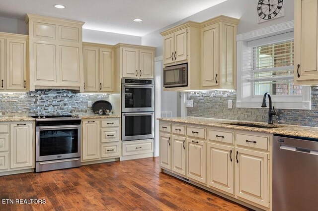3292 Moss Arcott Rd, Celina, TN 38551 - kitchen with stainless steel appliances, cream cabinetry, a sink, decorative backsplash, and recessed lighting