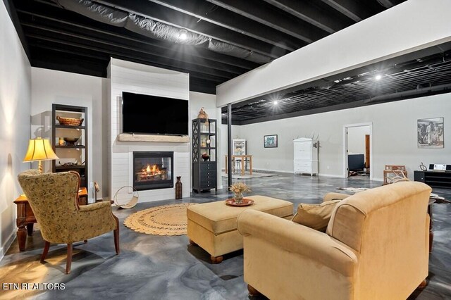 3292 Moss Arcott Rd, Celina, TN 38551 - living area with finished concrete floors, a glass covered fireplace, and baseboards