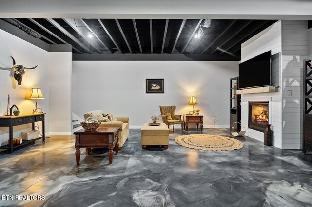 3292 Moss Arcott Rd, Celina, TN 38551 - living area featuring finished concrete floors, a large fireplace, and baseboards