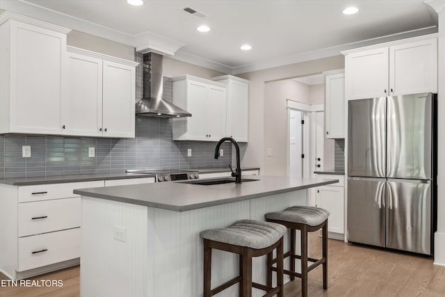 1007 Wigmore Way, Knoxville, TN 37932 - kitchen featuring appliances with stainless steel finishes, wall chimney range hood, a breakfast bar area, light wood-style floors, and recessed lighting