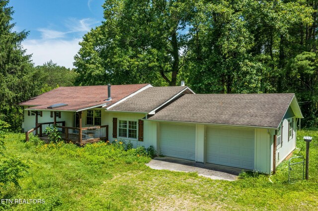 775 Middle Creek Rd, Cosby, TN 37722 - single story home with driveway, a garage, a shingled roof, a front lawn, and a wooden deck