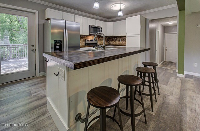 775 Middle Creek Rd, Cosby, TN 37722 - kitchen with appliances with stainless steel finishes, wood counters, tasteful backsplash, crown molding, and white cabinets