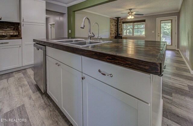 775 Middle Creek Rd, Cosby, TN 37722 - kitchen with dishwasher, light wood-style floors, ornamental molding, white cabinetry, and a wood stove