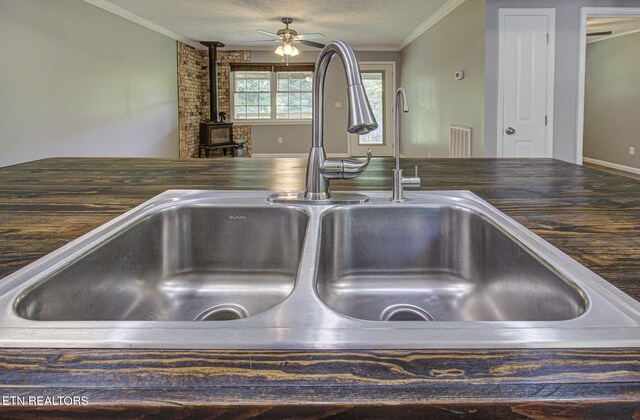 775 Middle Creek Rd, Cosby, TN 37722 - kitchen view of ornamental molding, a ceiling fan, a wood stove, and wooden counters
