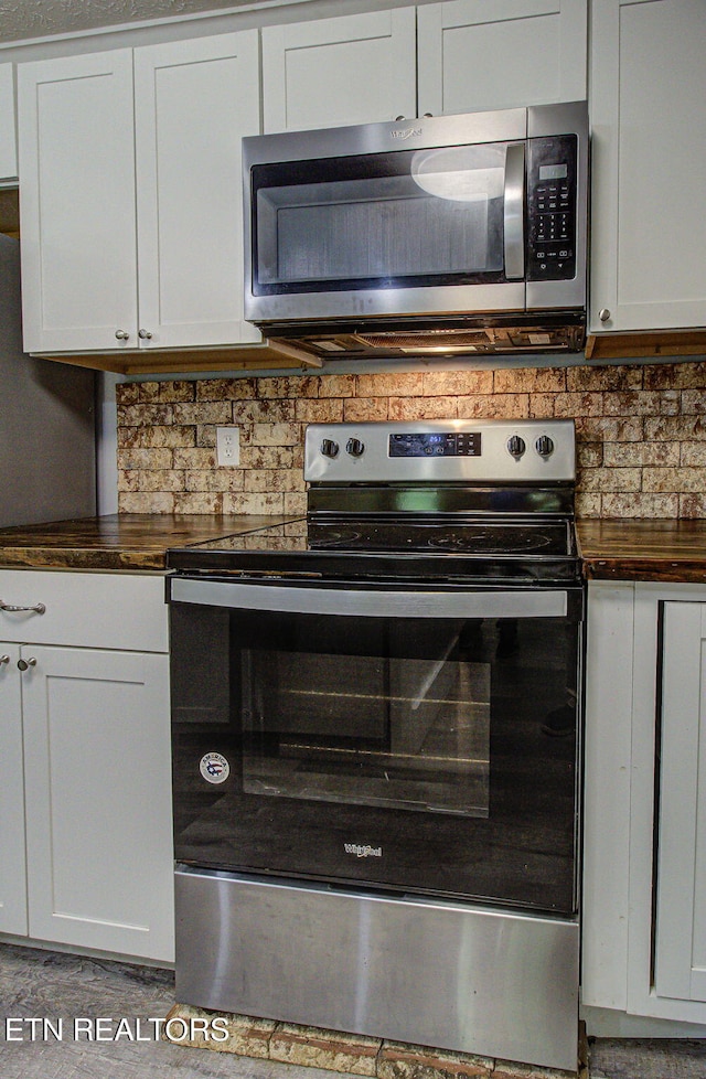 775 Middle Creek Rd, Cosby, TN 37722 - kitchen view of stainless steel appliances, tasteful backsplash, white cabinets, and wooden counters