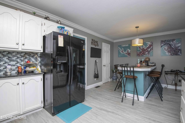 1246 Laurel Bluff Rd, Kingston, TN 37763 - kitchen featuring black refrigerator with ice dispenser, white cabinets, light wood-style floors, tasteful backsplash, and crown molding