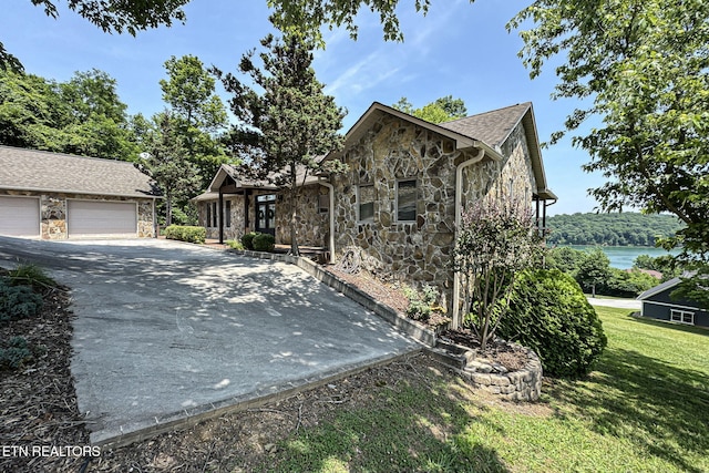 226 Mountain Crest Dr, Lafollette, TN 37766 - view of property exterior featuring stone siding, a garage, a yard, and an outdoor structure