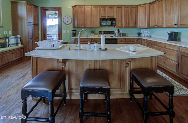 226 Mountain Crest Dr, Lafollette, TN 37766 - kitchen featuring black microwave, white electric range oven, a kitchen bar, light countertops, and wood finished floors