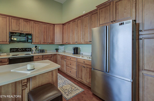 226 Mountain Crest Dr, Lafollette, TN 37766 - kitchen with freestanding refrigerator, black microwave, range with electric cooktop, dark wood-style floors, and light countertops