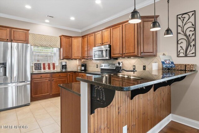 140 Broadleaf Ln Unit 100, Caryville, TN 37714 - kitchen featuring appliances with stainless steel finishes, brown cabinetry, a peninsula, a breakfast bar, and backsplash