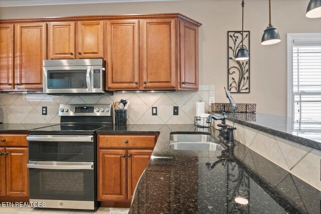 140 Broadleaf Ln Unit 100, Caryville, TN 37714 - kitchen featuring stainless steel appliances, brown cabinets, dark stone countertops, pendant lighting, and backsplash