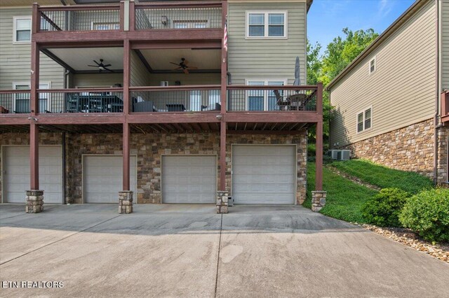 140 Broadleaf Ln Unit 100, Caryville, TN 37714 - rear view of house featuring a balcony, an attached garage, concrete driveway, and stone siding
