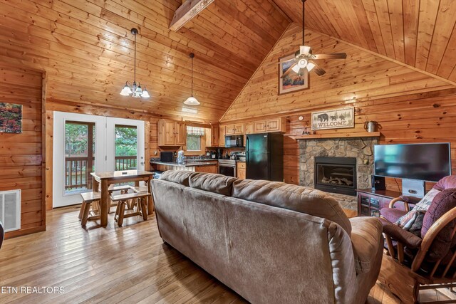 1528 Rainbow Ridge Way, Sevierville, TN 37862 - living room with wooden walls, ceiling fan, light wood-type flooring, high vaulted ceiling, and a fireplace
