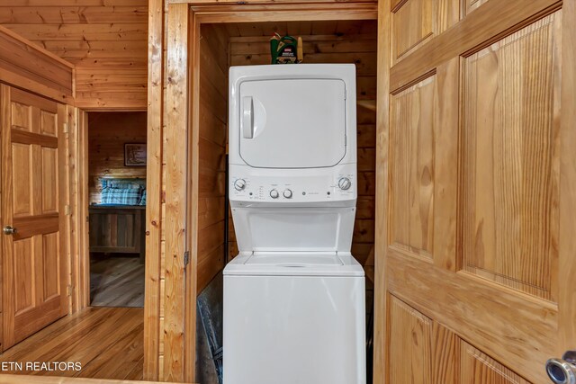 1528 Rainbow Ridge Way, Sevierville, TN 37862 - washroom featuring stacked washer and clothes dryer, wooden walls, and wood finished floors