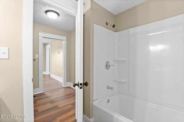 715 E Kentucky Ave, Lafollette, TN 37766 - bathroom with wood finished floors, a textured ceiling, and washtub / shower combination