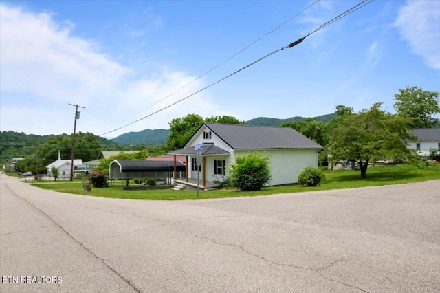715 E Kentucky Ave, Lafollette, TN 37766 - view of front of property featuring a mountain view, a front lawn, a porch, and a metal roof