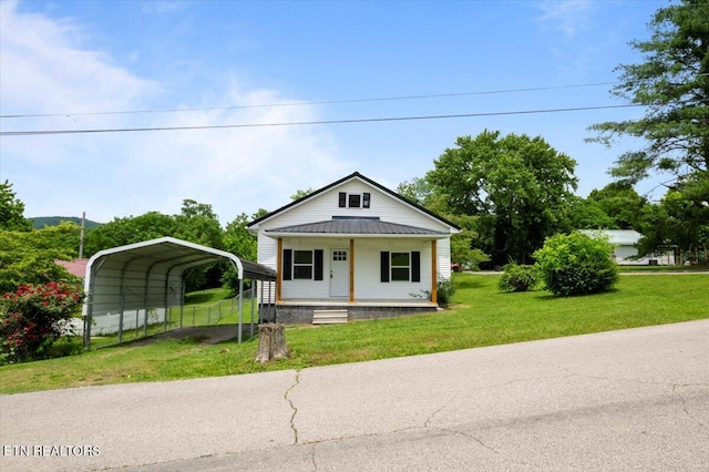 715 E Kentucky Ave, Lafollette, TN 37766 - bungalow featuring a detached carport, covered porch, a front lawn, a metal roof, and driveway