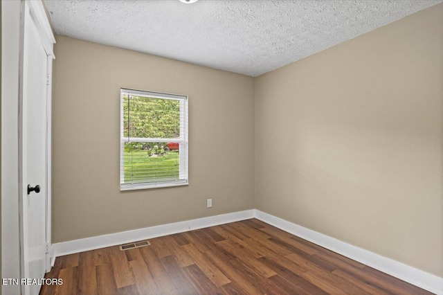 715 E Kentucky Ave, Lafollette, TN 37766 - unfurnished bedroom with dark wood-style flooring and a textured ceiling