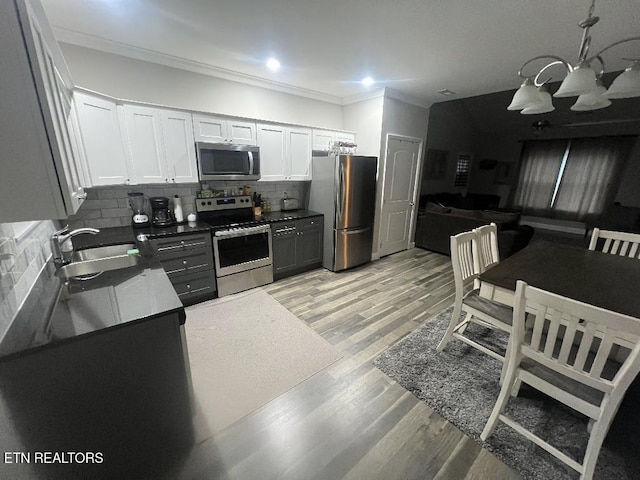 326 Shooting Star Loop Unit 201, Townsend, TN 37882 - kitchen featuring stainless steel appliances, a chandelier, crown molding, dark countertops, and backsplash