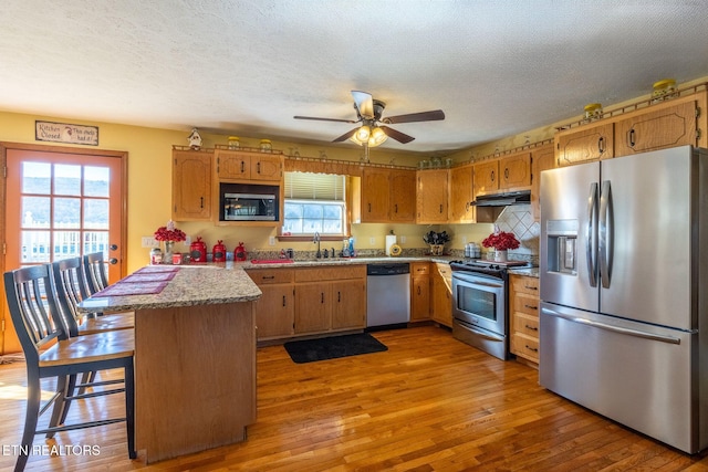 361 River Dr, Dunlap, TN 37327 - kitchen with appliances with stainless steel finishes, a peninsula, healthy amount of natural light, light wood-style floors, and a textured ceiling