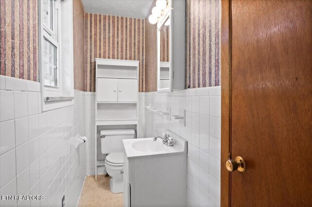 220 Lillywood Dr, Lafollette, TN 37766 - half bath with tile walls, vanity, wainscoting, wallpapered walls, and tile patterned floors
