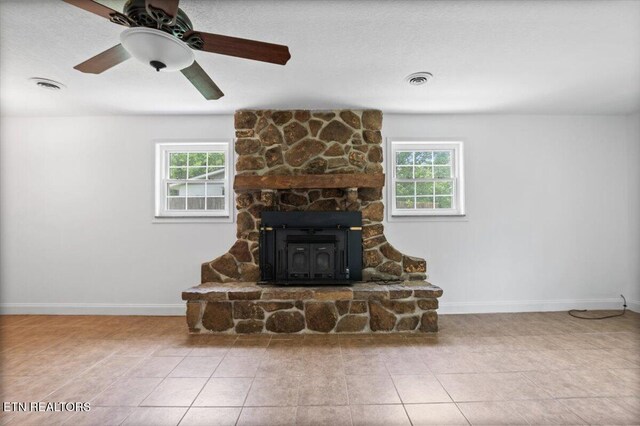 220 Lillywood Dr, Lafollette, TN 37766 - unfurnished living room with plenty of natural light, tile patterned flooring, a wood stove, and ceiling fan