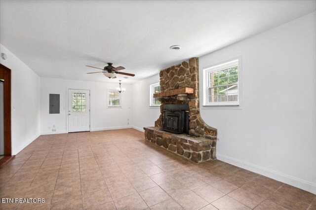 220 Lillywood Dr, Lafollette, TN 37766 - unfurnished living room with electric panel, a ceiling fan, tile patterned floors, and a wood stove