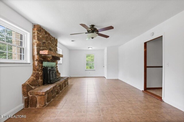 220 Lillywood Dr, Lafollette, TN 37766 - unfurnished living room featuring ceiling fan, a wood stove, and light tile patterned floors