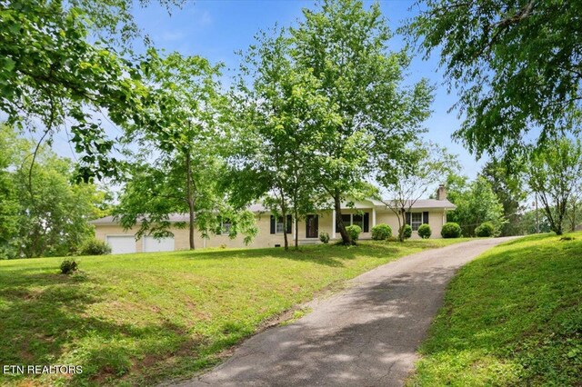 220 Lillywood Dr, Lafollette, TN 37766 - ranch-style house featuring a chimney, a front yard, driveway, and a garage