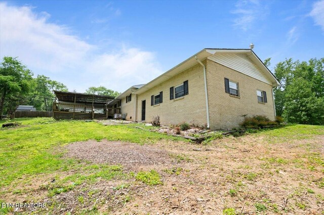 220 Lillywood Dr, Lafollette, TN 37766 - back of house with brick siding, a lawn, and a deck