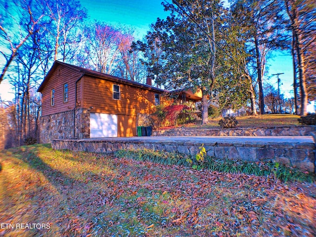 705 S 11th St, Lafollette, TN 37766 - view of side of home with an attached garage, stone siding, and a chimney